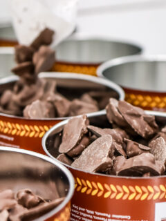 Chocolate covered peanut clusters in open top cans from Aunt Ruby's Peanuts.