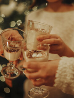 Family drinking homemade eggnog by the Christmas tree having fun