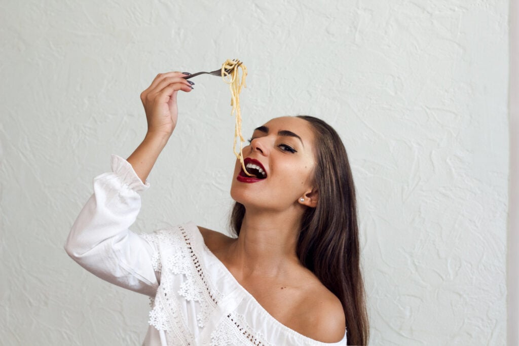 Woman suggestively eating pasta