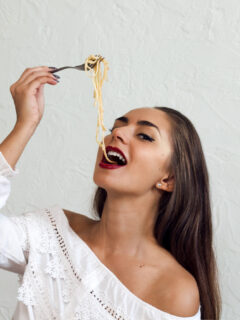 Woman suggestively eating pasta