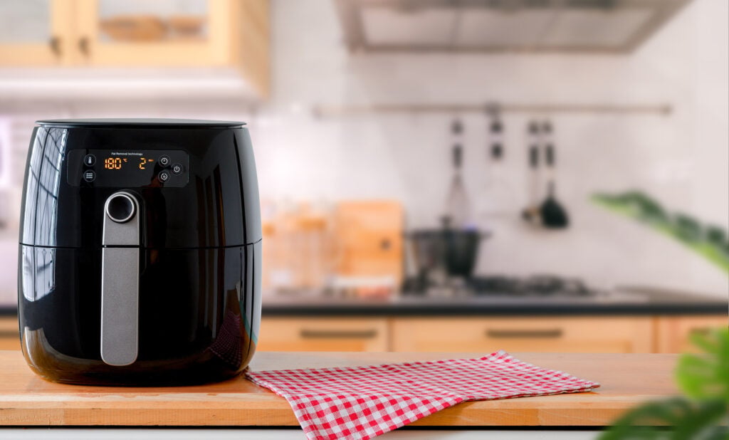 Air fryer machine cooking in kitchen.