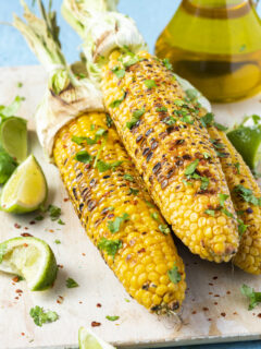 Roasted or Grilled Sweet Corn Cobs with Garlic, Coriander, Lime . Mexican Street Food. Top Down View.
