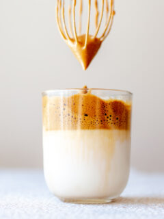 Using a whisk to froth coffee creamer for Dalgona coffee