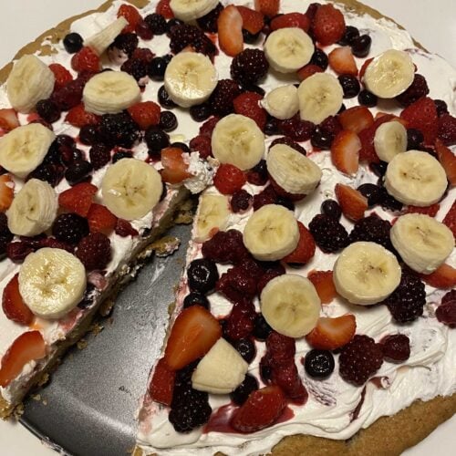 Our editor's cookie pizza, topped with bananas, strawberries, raspberries, and blueberries. One piece is missing.