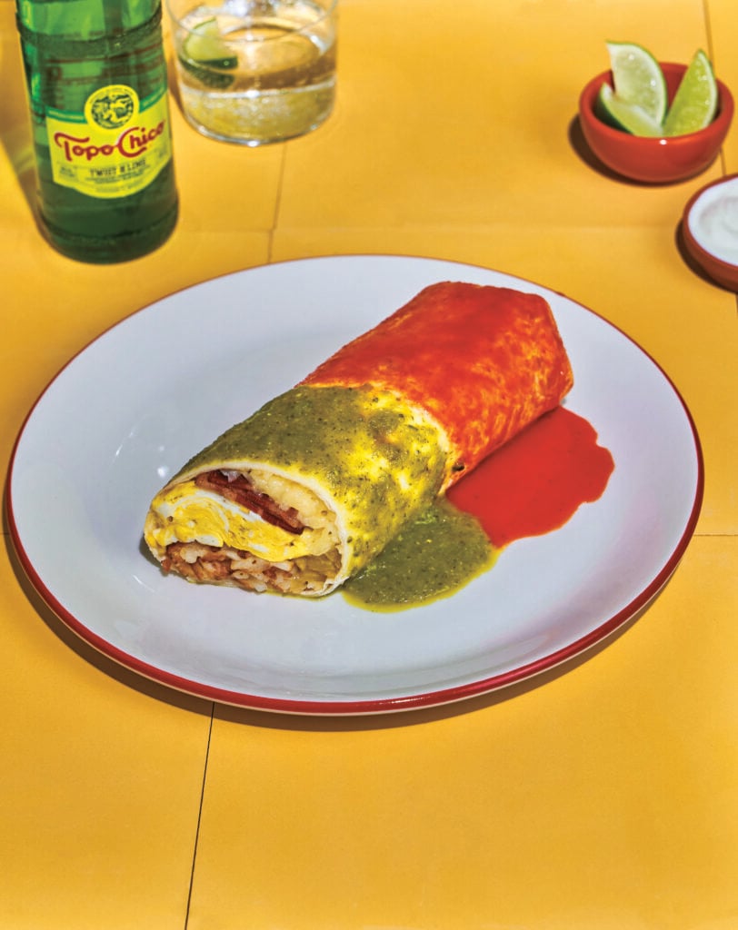 New Mexico Breakfast Burrito covered in red and green sauce on a white plate