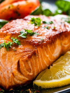 Barbecued salmon, fried potatoes and vegetables on wooden background