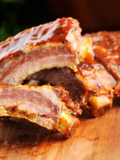 Grilled sliced barbecue pork ribs on a wooden background.