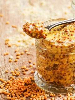 Mustard with grains, ready hot sauce, old wooden kitchen table