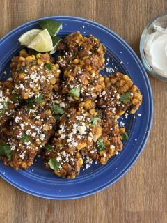 Sweet corn elotes latkes on a blue plate