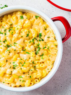 Mac and cheese in red pot, top view. Traditional American food.