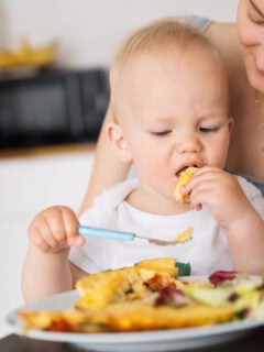 Mother with her child eating together and have a fun